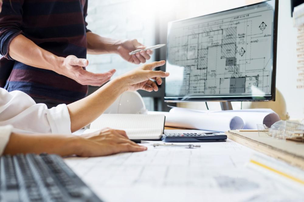 Architecte montrant un plan sur un ordinateur